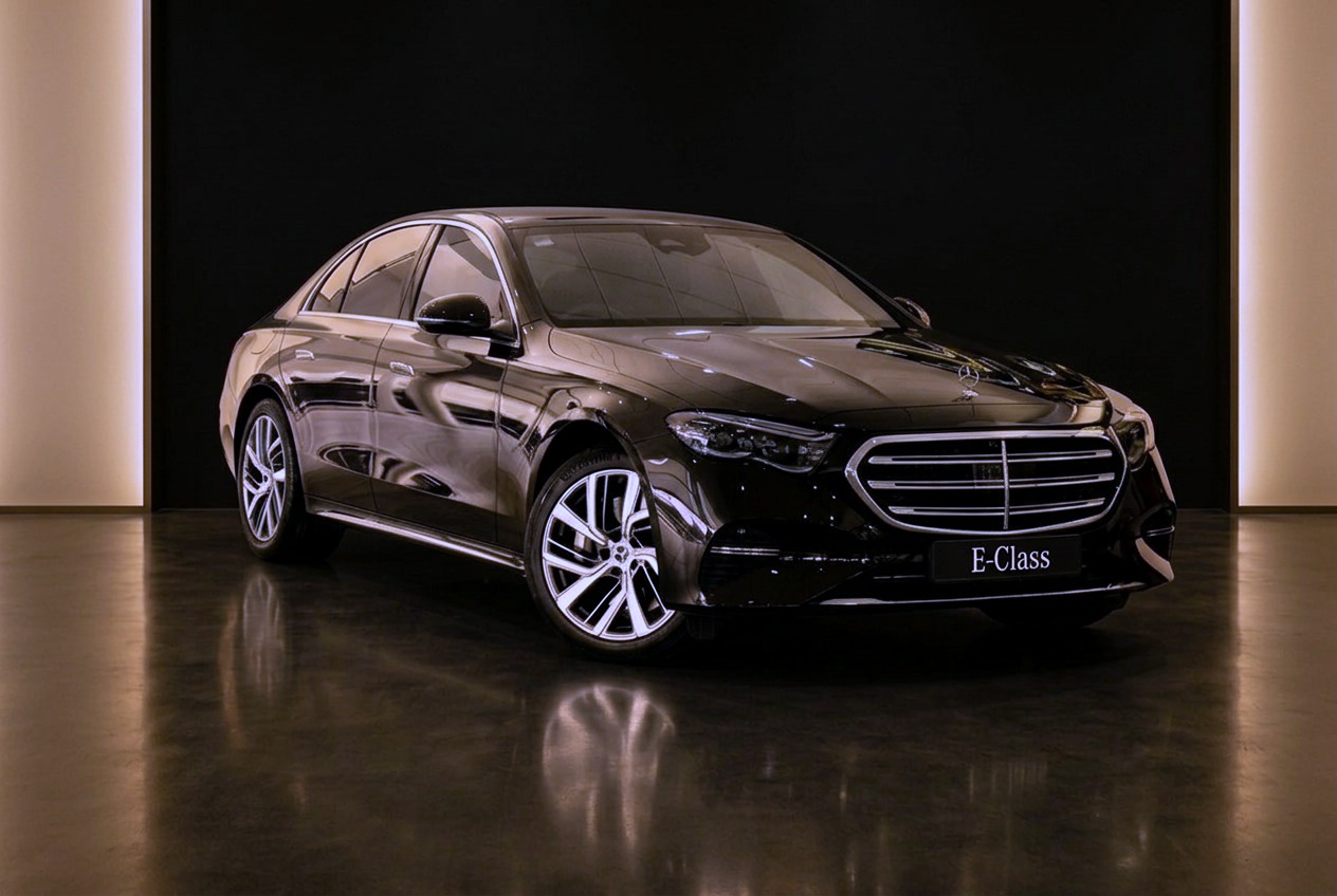 Black executive saloon with chrome grille and standing bonnet ornament in a dark studio